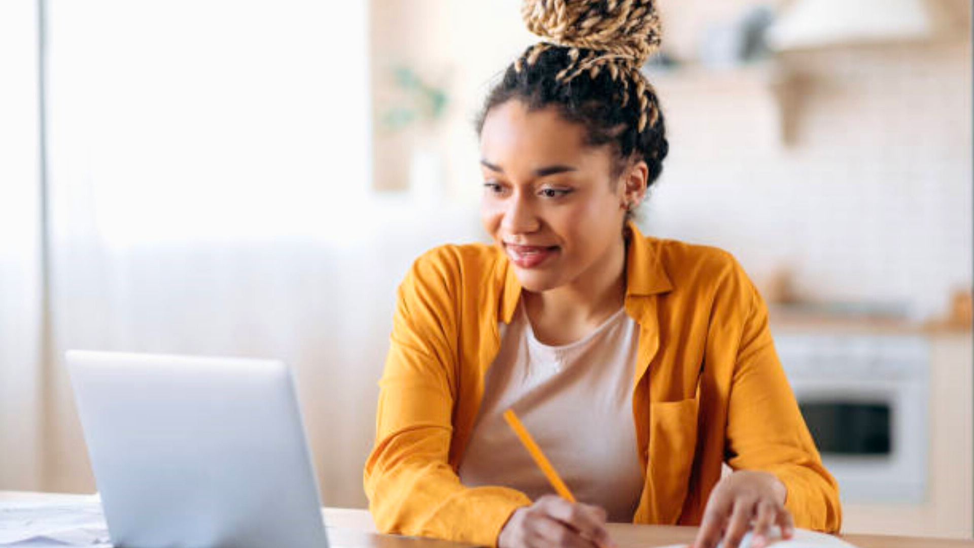 Header African American woman with African dreadlocks, studying on laptop, writing notes